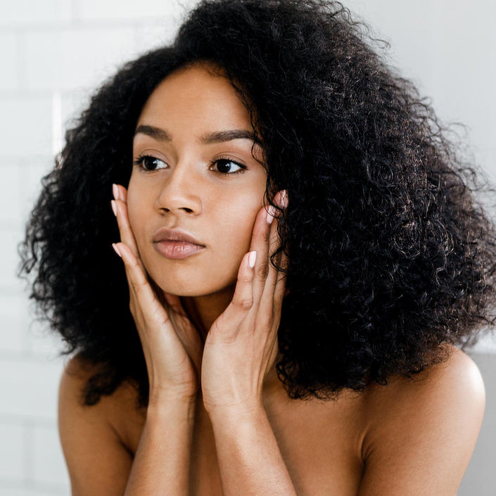 A woman applying moisturizer